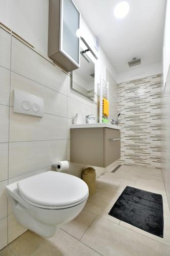 a bathroom with a white toilet and a sink at Apartment Mary 3 in Malinska