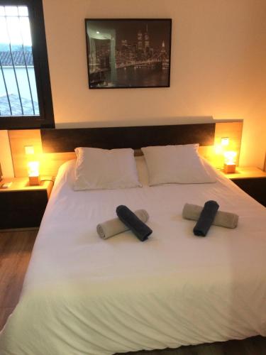 un grand lit blanc avec deux oreillers dessus dans l'établissement Appart 2 pièces indépendant dans villa proche centre ville au calme, à Mandelieu-la-Napoule