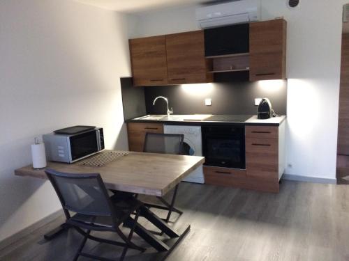 - une cuisine avec une table en bois et un ordinateur dans l'établissement Appart 2 pièces indépendant dans villa proche centre ville au calme, à Mandelieu-la-Napoule