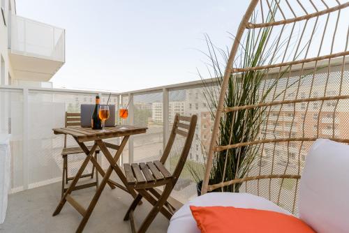 balkon ze stołem i krzesłem w obiekcie Lumina premium apartments with balcony, parking w Łodzi