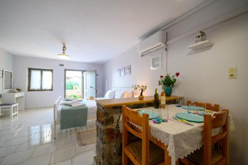 a dining room and living room with a table and chairs at Κοχύλι in Kotrónion