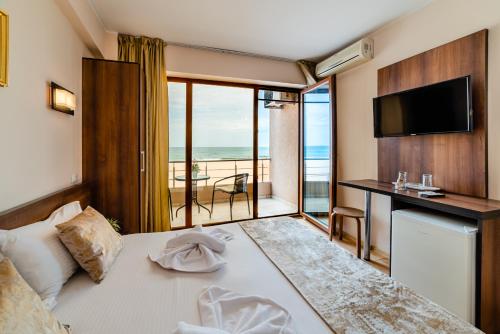 a bedroom with a bed with a view of the ocean at Hotel CASA ROYAL pe plaja Belona in Eforie Nord
