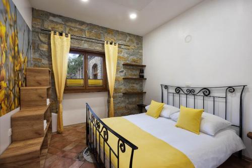 1 dormitorio con 1 cama grande con almohadas amarillas en TouristFarm - apartments "RED FAIRYTALE" en Marezige