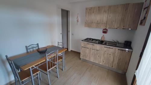 uma pequena cozinha com uma mesa e um fogão forno superior em Casa vacanze Tortolì em Tortolì