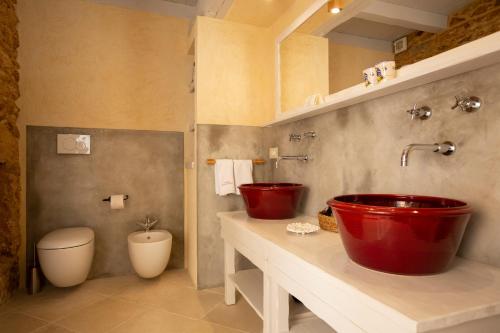 uma casa de banho com um lavatório vermelho e um WC. em Masseria Borgo Mortella em Lecce