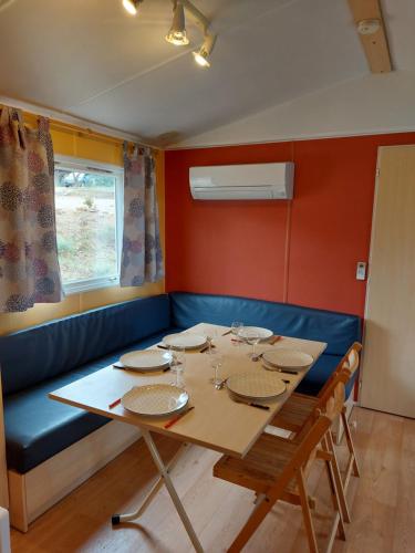 a dining room with a table and a blue couch at LAVATOGGIO in Lumio