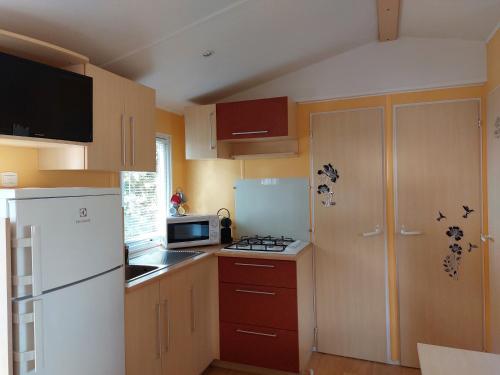 a kitchen with a white refrigerator and a microwave at LAVATOGGIO in Lumio