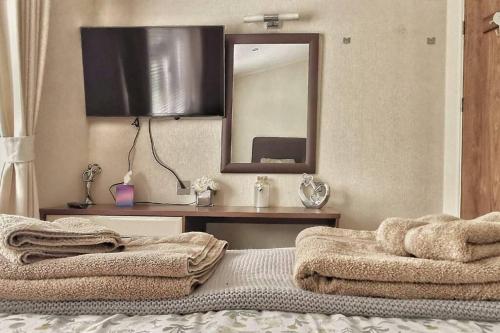 a bedroom with a bed with a mirror and a table at Lakeside View in Wisbech