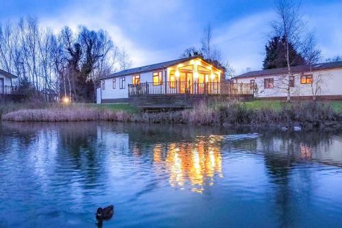 a house sitting on the side of a river at night at Lakeside View in Wisbech