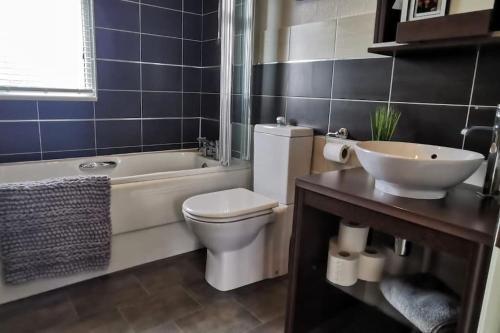 a bathroom with a tub and a toilet and a sink at Lakeside View in Wisbech