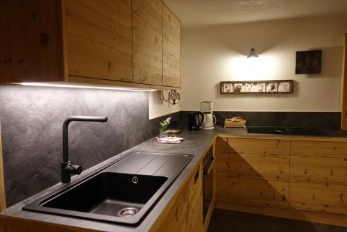 una cocina con fregadero y armarios de madera en Hinterauerhof, en Matrei in Osttirol