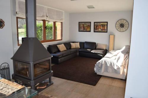 a living room with a fireplace and a couch at Casa con jardín en Rascafría in Rascafría