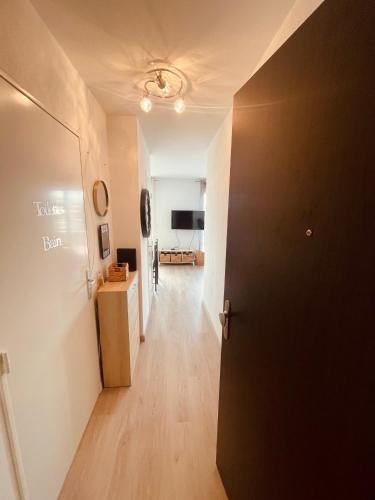 a hallway with a black door and a living room at Grand studio toit terrase Ajaccio in Ajaccio