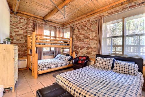 1 dormitorio con 2 literas en una pared de ladrillo en Chalet L'Ours charmeur du lac Sept-Îles en Saint-Raymond