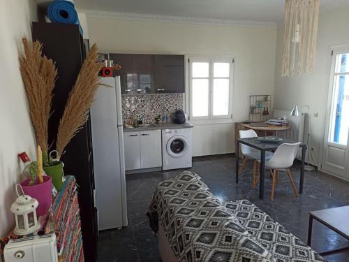 een keuken en een woonkamer met een tafel en een koelkast bij Εξαιρετικό διαμέρισμα δίπλα στο λιμανι! Καινουριο in Naxos Chora