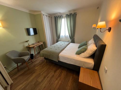 a bedroom with a bed and a chair and a window at Le Clos d'Orange - Hotel & ville de Provence in Orange