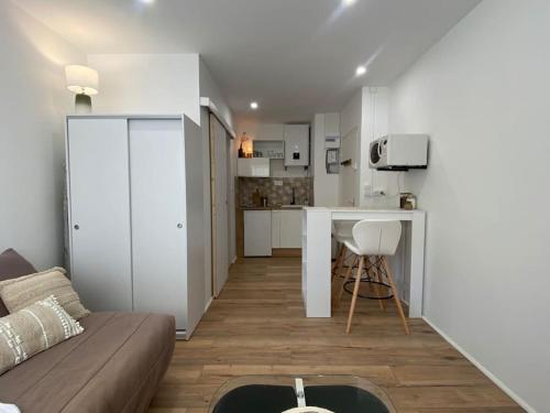 un salon avec un canapé et une cuisine dans l'établissement Mon petit studio à la mer, à Gruissan