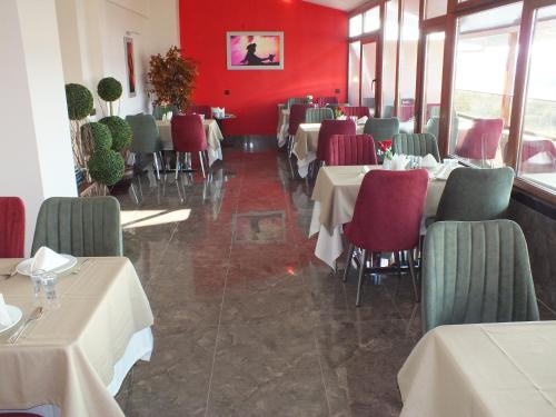 a restaurant with tables and chairs and red walls at Lifos Hotel in Kayseri