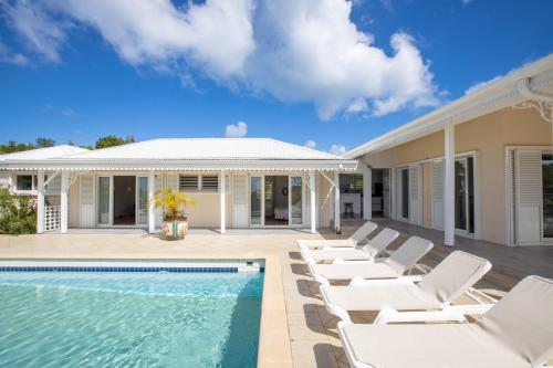 a villa with a swimming pool and lounge chairs at Villa Madras in Les Terres Basses