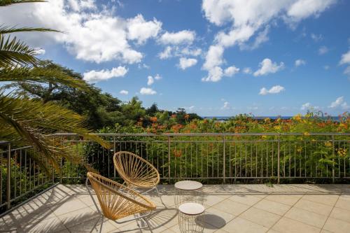 a patio with two chairs and a fence at Villa Madras in Les Terres Basses
