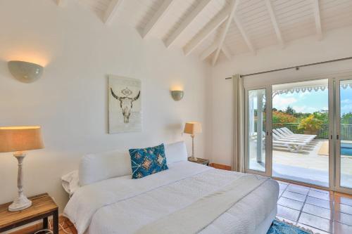 a bedroom with a bed and a sliding glass door at Villa Madras in Les Terres Basses