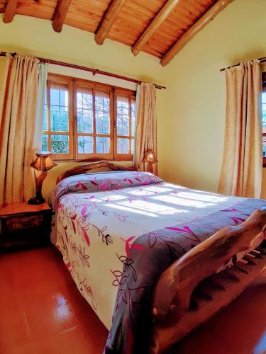 a bedroom with a large bed in a room with windows at Cabañas Calderón II in San Rafael