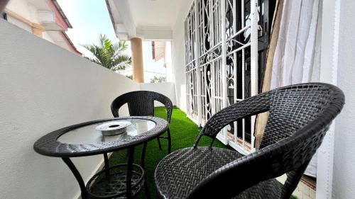 two chairs and a table on a balcony at YB Guest House 4 Bilik 5 Katil in Cukai