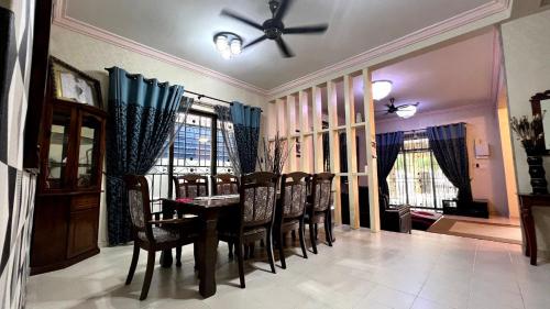 a dining room with a table and chairs and a ceiling fan at YB Guest House 4 Bilik 5 Katil in Cukai