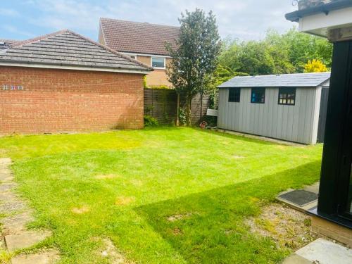 a yard with a brick house and a garage at The Ely Retreat in Ely