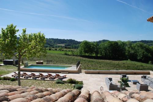 a backyard with a swimming pool and a field at Bastide Saint Maurin in Ansouis