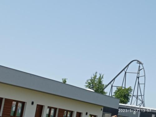 a roller coaster in the sky behind a building at Loft Park Zator in Zator