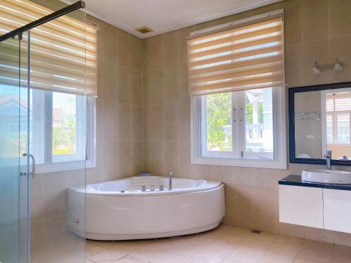 een grote badkamer met een bad en een wastafel bij Villa Sea Link - Phan Thiết in Phan Thiet