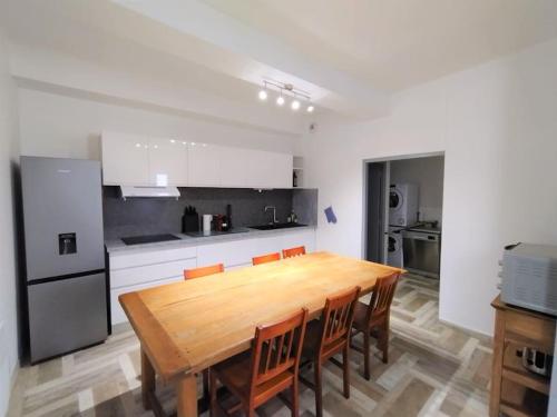 une grande cuisine avec une table et des chaises en bois dans l'établissement Maison de village avec terrasse proche plages, à Lespignan