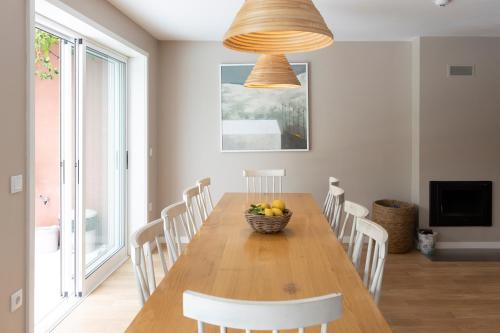 a dining room with a table with chairs and a bowl of fruit at Casa dos Pinheiros 109 - Private Villa with pool & heated SPA in Porto
