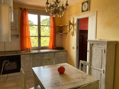 een keuken met een tafel met een sinaasappel erop bij tre case in Gambassi Terme