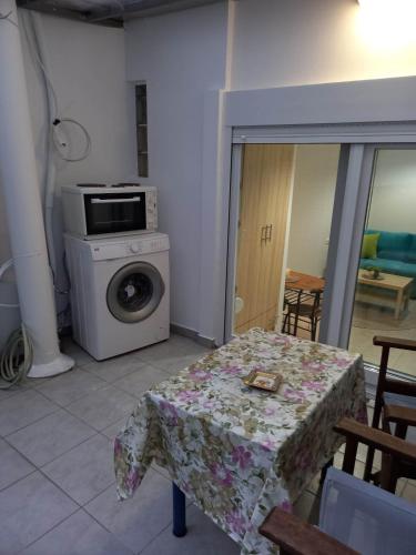 a kitchen with a table and a washing machine at Το Κεντρικό διαμέρισμα της πόλης in Larisa