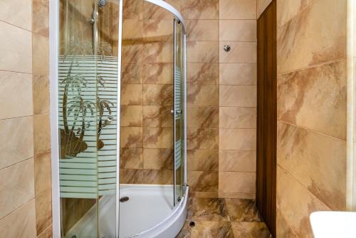 um chuveiro com uma porta de vidro na casa de banho em Hotel CASA ROYAL pe plaja Belona em Eforie Nord