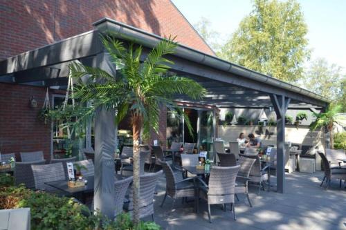 un patio con tavolo, sedie e asciugacapelli di Chalet vakantiepark Kleine Belties 18 a Hardenberg