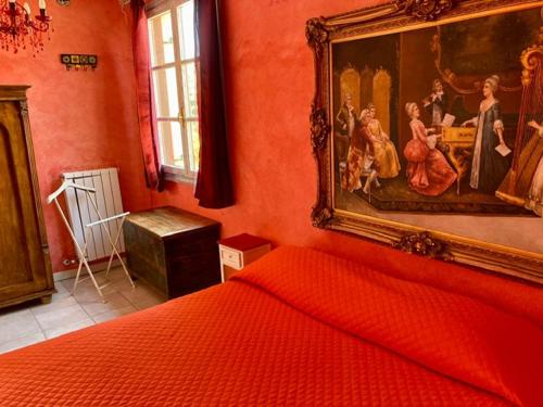 een rode slaapkamer met een schilderij aan de muur en een bed bij tre case in Gambassi Terme