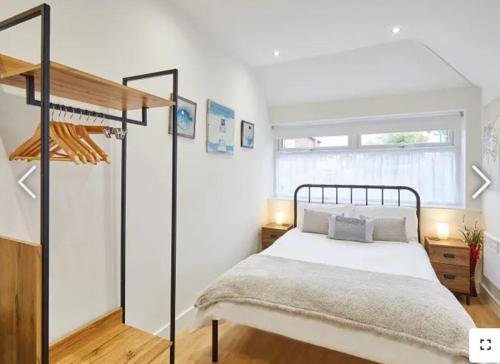 a white bedroom with a bed and a window at The Guest Place in Redcar