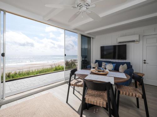 a dining room with a table and a view of the beach at El Mar Villa in Ponte Vedra Beach