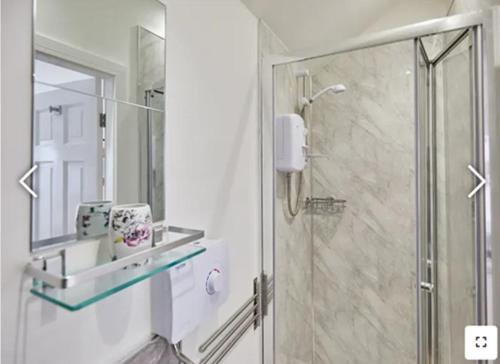 W łazience znajduje się prysznic i przeszklona kabina prysznicowa. w obiekcie The Guest Place w mieście Redcar