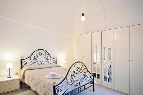 una camera con un grande letto e un armadietto bianco di Casa Silvana a Locorotondo