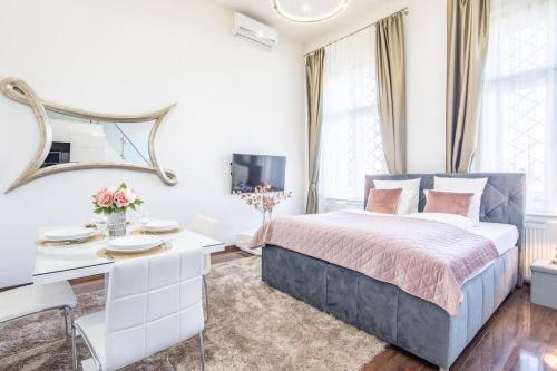 Habitación blanca con cama y escritorio en Opera Luxury Studio Apartment, en Budapest