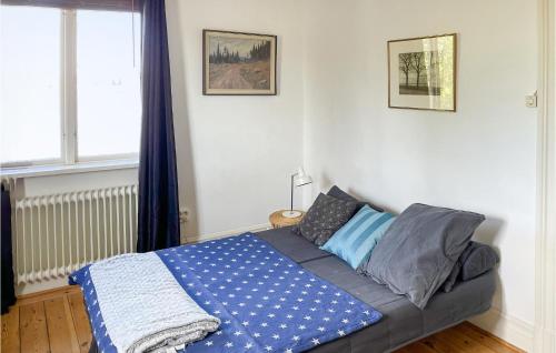 a bedroom with a bed with a blue blanket on it at Gorgeous Home In Lindesberg in Lindesberg