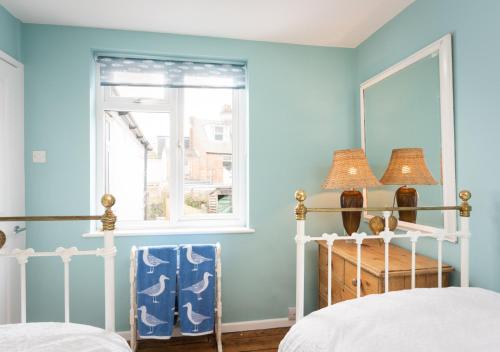 Dormitorio azul con cama y espejo en Trinity Terrace, en Weymouth