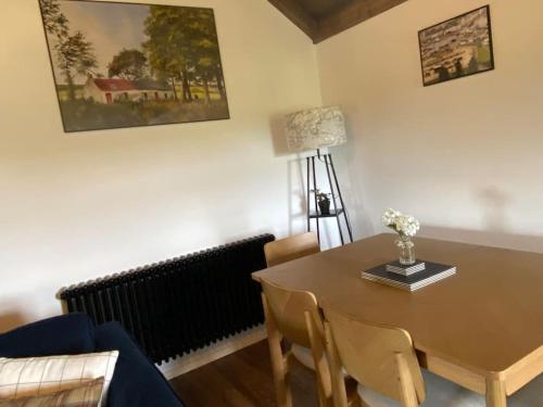 a dining room with a table and a couch at Farm Stay at THE GLEBE COTTAGE KILREA in Tamlaght