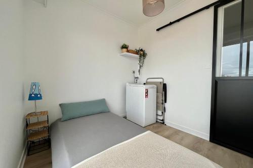 a room with a refrigerator and a bed in it at Accès direct à la Plage Garage fermé in Les Sables-dʼOlonne