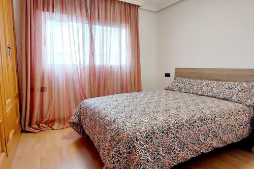 um quarto com uma cama e uma grande janela em Acogedor piso cerca de la playa em Ceuta