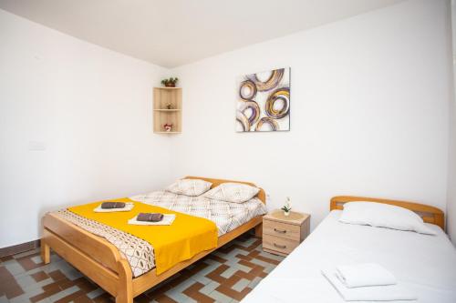 - une chambre avec 2 lits et une couverture jaune dans l'établissement Apartments Jelena Ulcinj, à Ulcinj